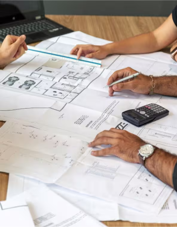 arquitectos trabajando con planos en una oficina